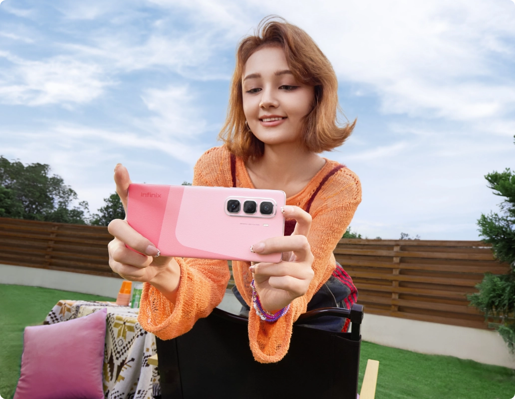 Infinix Hot 50 Pro Plus pink two-tone back held for a selfie