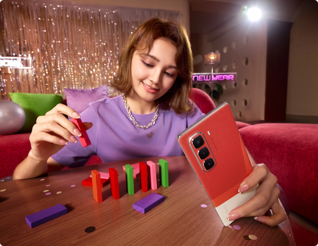 Infinix Hot 50 Pro Plus red two-tone back held at a table
