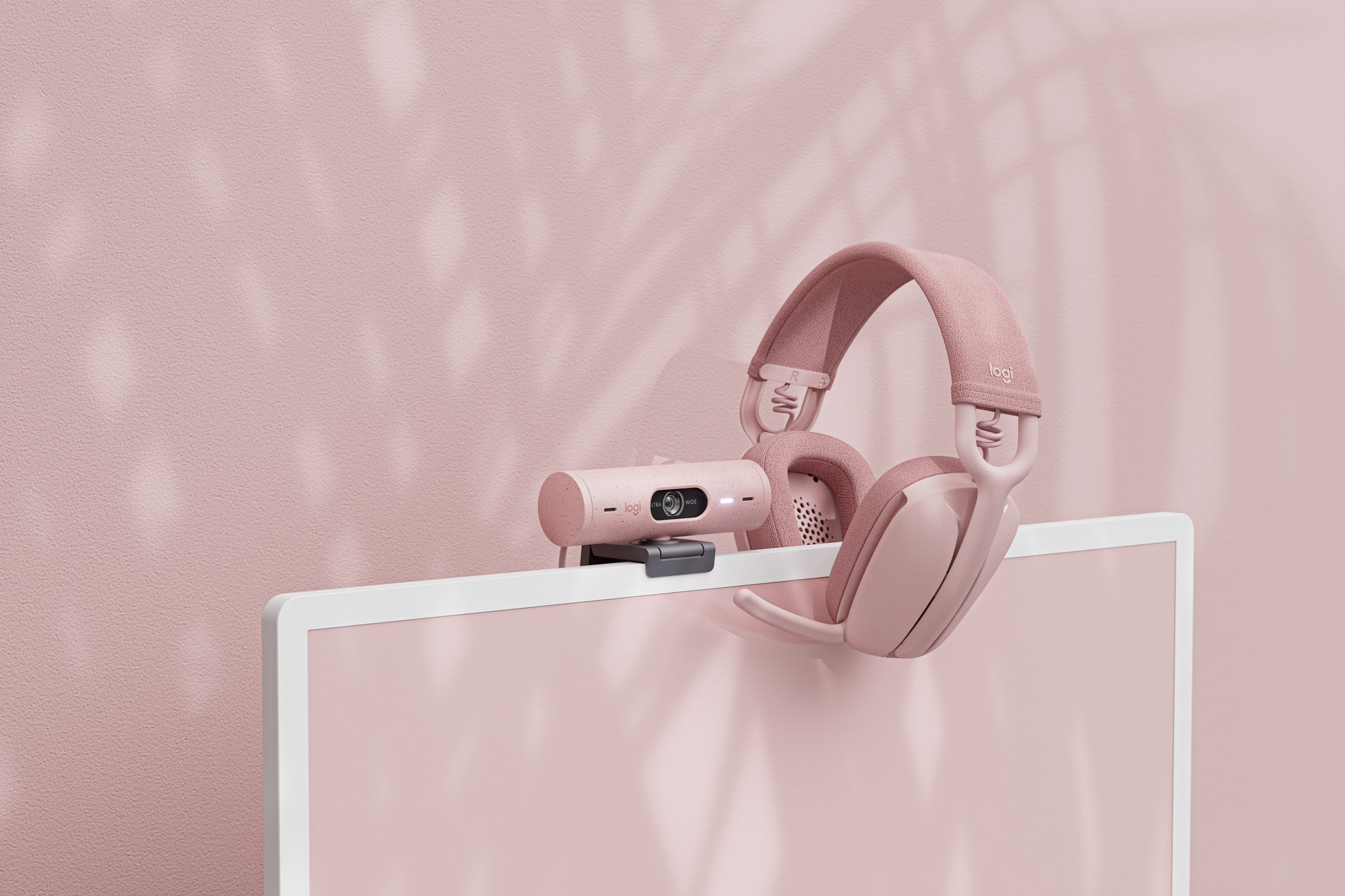 Pink Logitech Brio 500 with Pink Headsets on it's right