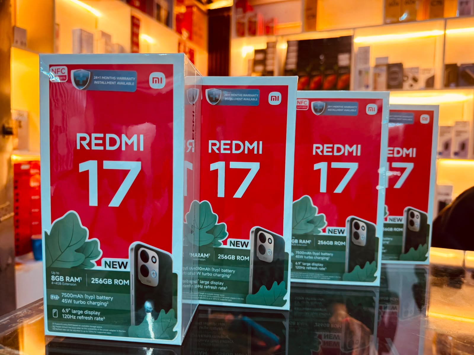Official Redmi 17 retail boxes on a shop counter, showing the 7,500mAh 4G model