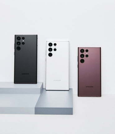 Samsung Galaxy S22 Ultra backs in Phantom Black, Phantom White and Burgundy on display blocks