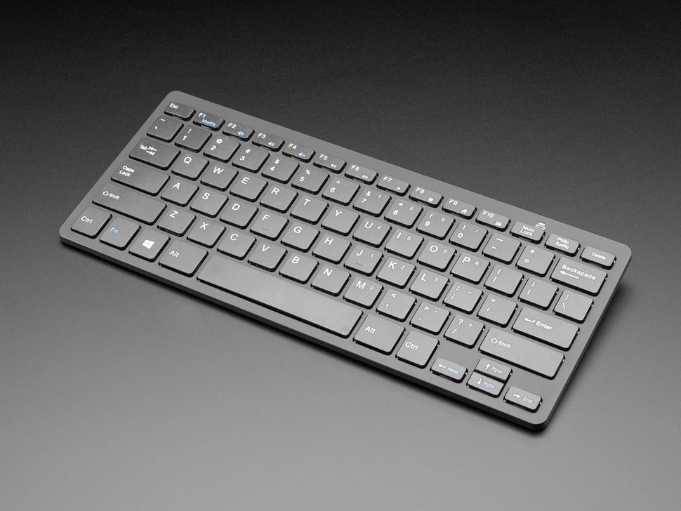 A wireless keyboard with a gray color scheme, featuring a full QWERTY layout and a touchpad.